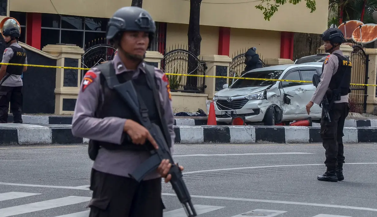 Polisi bersenjata berjaga di sekitar Mapolda Riau, Rabu (16/5). Terduga teroris masuk menyerang Mapolda Riau dengan mengendarai sebuah minibus. (WAHYUDI/AFP)