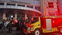 Petugas pemadam kebakaran berupaya menjinakkan si jago merah yang melalap salah satu ruangan Kantor Pos Plaza Tanjung Karang. Foto : (Liputan6.com/Ardi).
