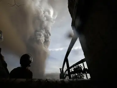Sejumlah orang menyaksikan Gunung Api Taal erupsi di Tagaytay, Provinsi Cavite, Filipina, Minggu (12/1/2020). Suara bergemuruh terdengar disertai gempa bumi dan kilat di atas puncaknya. (AP Photo/Aaron Favila)