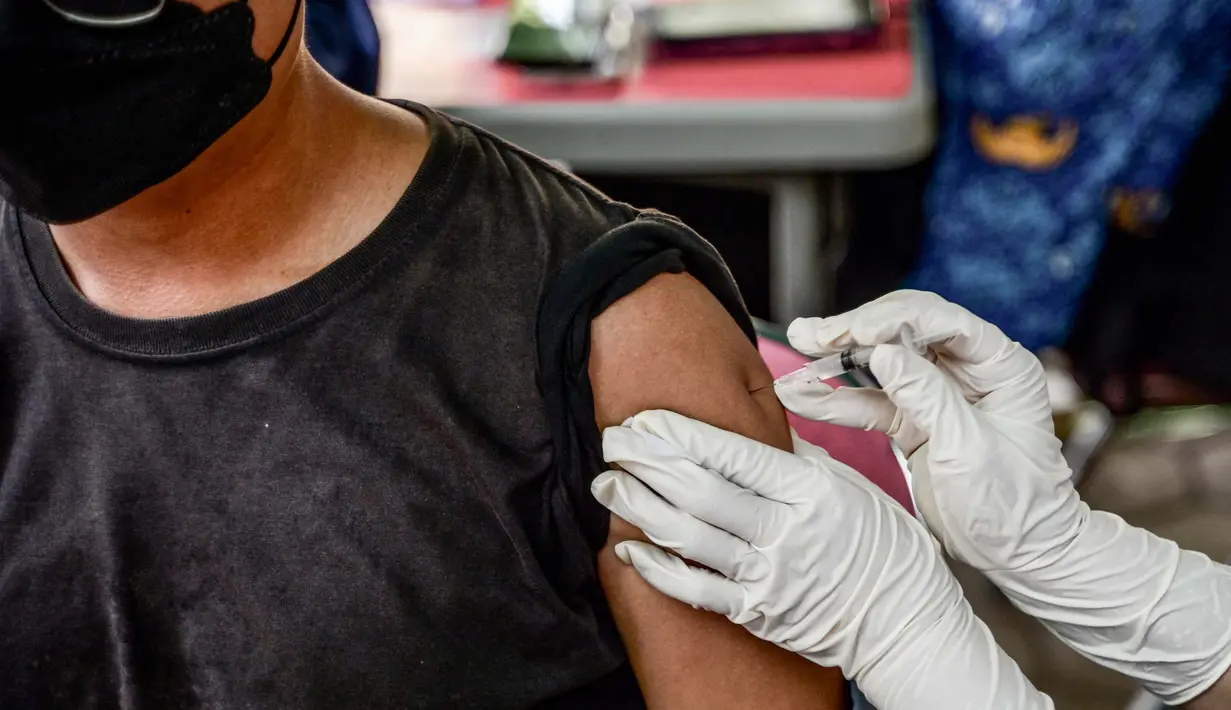 Seorang petugas kesehatan menyuntikan vaksin Inavac untuk Covid-19 di kantor dinas kesehatan provinsi Jakarta pada 19 Desember 2023. (BAY ISMOYO/AFP)