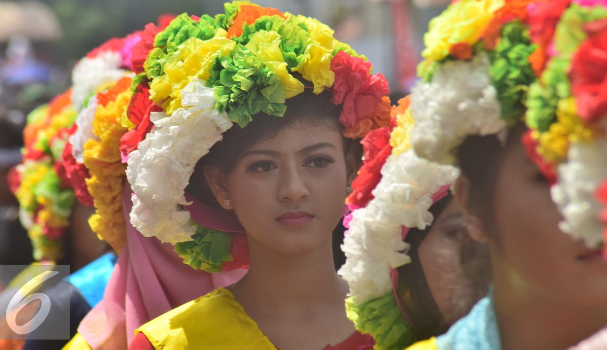 Peserta wanita mengenakan mahkota dari bunga saat pawai Tradisi Ngarot di Indramayu, Minggu, (9/10). Mahkota bunga dalam Tradisi Ngarot diartikan sebagai lambang kesucian. (Liputan6.com/Gholib)