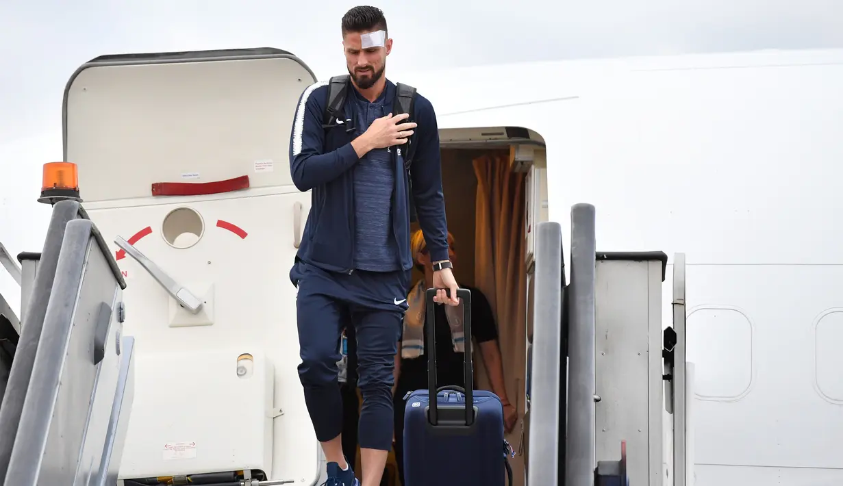Penyerang Timnas Prancis,  Olivier Giroud dengan kepala diperban turun dari pesawat setibanya di bandara Sheremetyevo Moskow, Minggu (10/6). Giroud bersama salah satu tim unggulan Piala Dunia 2018, Prancis, tiba di Rusia. (AFP/Yuri KADOBNOV)