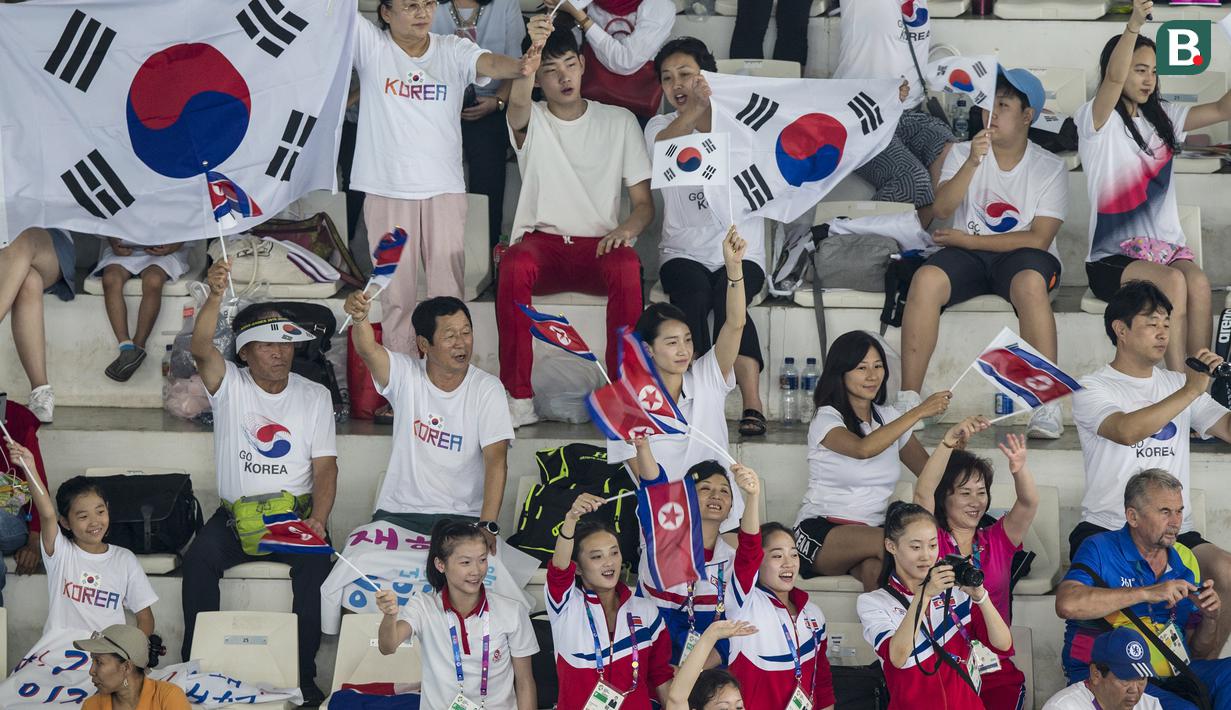 Sejumlah suporter Korea Utara dan Korea Selatan bersatu saling mendukung saat menyaksikan pertandingan renang indah di Stadion Aquatic Senayan, Jakarta, Rabu (29/8/2018). (Bola.com/Vitalis Yogi Trisna)