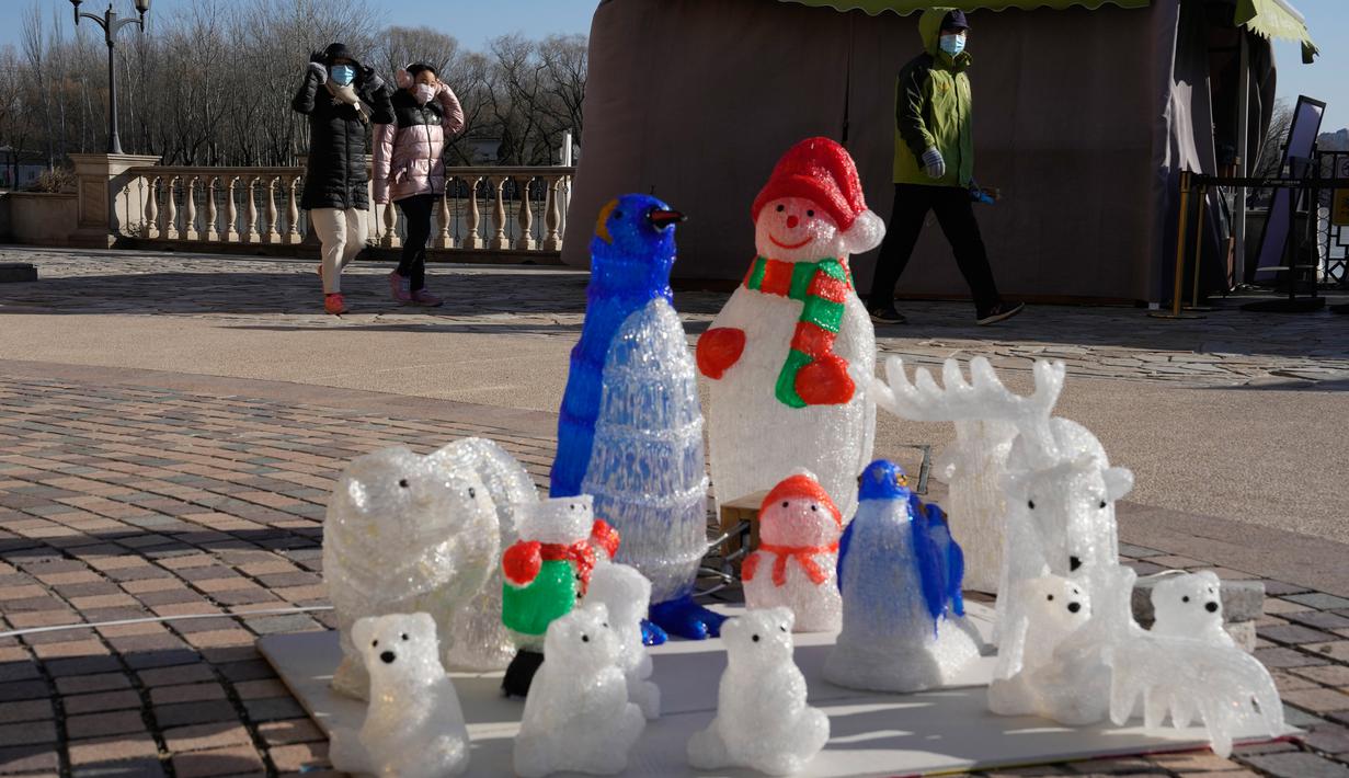 Pengunjung pusat perbelanjaan melewati dekorasi meriah di Beijing, China, 27 Desember 2022. Perusahaan menyambut baik keputusan China untuk mengakhiri karantina bagi pelancong dari luar negeri sebagai langkah penting untuk menghidupkan kembali aktivitas bisnis yang merosot, sementara Jepang mengumumkan pembatasan pengunjung saat infeksi melonjak. (AP Photo/Ng Han Guan)