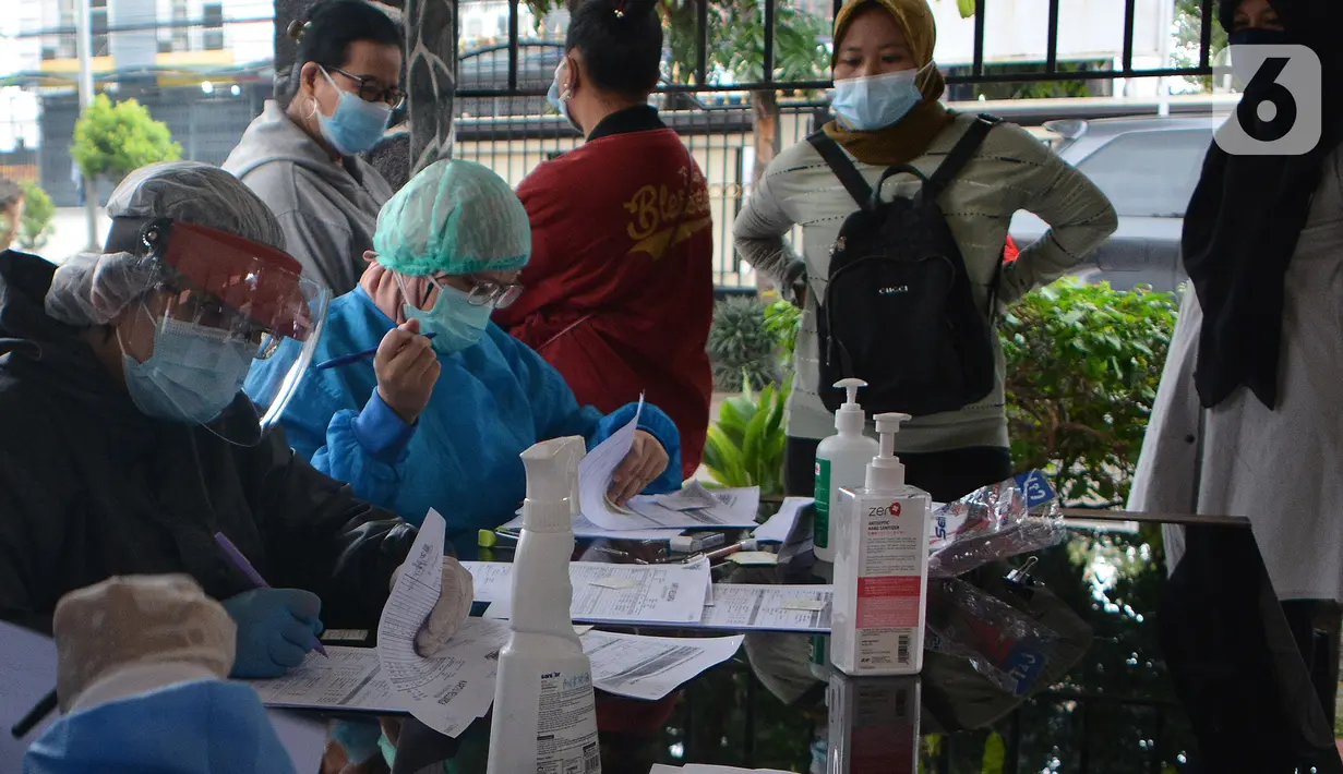 Petugas medis melakukan tes Swab PCR massal  di Kantor Kecamatan Pancoran Mas, Depok, Selasa (5/1/2021). Puskesmas Pancoran Mas melakukan tes Swab PCR kepada warga yang pernah memiliki riwayat kontak erat dengan pasien terkonfirmasi positif Covid-19. (merdeka.com/Arie Basuki)