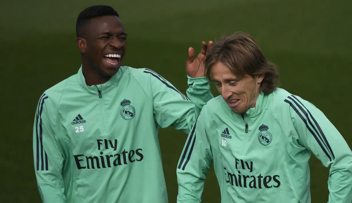 Striker Real Madrid, Vinicius Junior (kiri) dan gelandang Luka Modric tertawa saat menghadiri sesi pelatihan di tempat latihan tim Valdebebas, Spanyol (5/11/2019). Real Madrid akan melawan Galatasaray pada Grup A Liga Champions di Estadio Santiago Bernabeu. (AFP Photo/Pierre-Philippe Marcou)