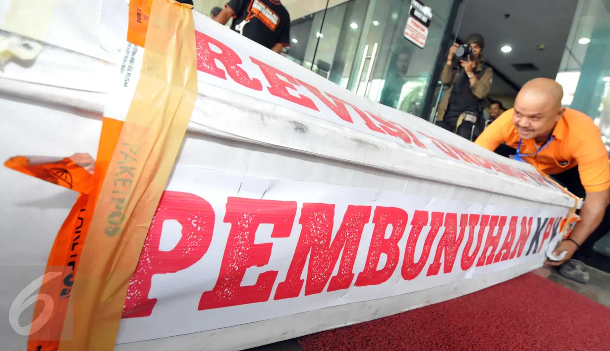 Sebuah peti mati berukuran kira-kira 2x0,5 m muncul tiba-tiba di Gedung KPK, Jakarta, Selasa (20/10). Peti yang bertuliskan "Revisi UU KPK, Pembunuhan KPK" itu dikirim oleh Bambang Saptono, warga Solo, Jawa Tengah. (Liputan6.com/Helmi Afandi)