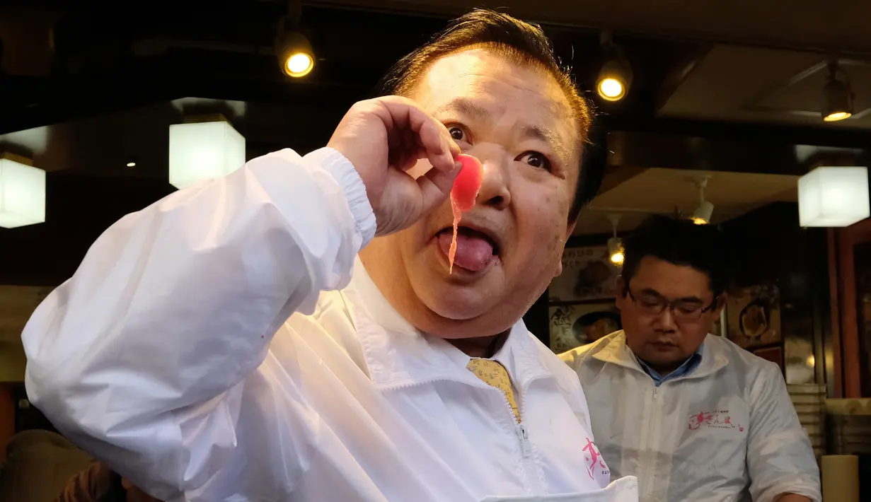 Pengusaha restoran sushi Jepang, Kiyoshi Kimura mencicipi fillet tuna sirip biru seberat 278 kg di restorannya, Tokyo, Sabtu (5/1). Tuna raksasa itu dibeli dalam lelang perdana 2019 dengan harga USD3,1 juta atau setara Rp43,4 miliar. (Kazuhiro NOGI/AFP)