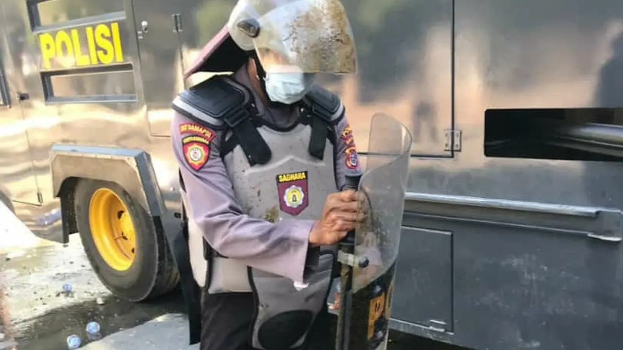 Seorang anggota polisi yang terkena lemparan kantong berisi tinja, demosntrasi yang digelar Senin (28/10/2019).(Liputan6.com/Ahmad Akbar Fua)