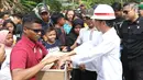 Presiden Joko Widodo atau Jokowi membagikan buku dan kain batik kepada warga yang tinggal di sekitar Bandara Soetta, Tangerang, Banten, Kamis (21/6). Bagi-bagi buku tersebut merupakan rutinitas Jokowi usai blusukan. (Liputan6.com/Angga Yuniar)