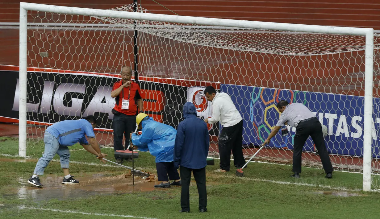Para petugas berusaha menguras air yang menggenangi lapangan di Stadion Patriot, Bekasi, Senin (13/11/2017). Drainase yang buruk menyebabkan lapangan terendam air. (Bola.com/M Iqbal Ichsan)