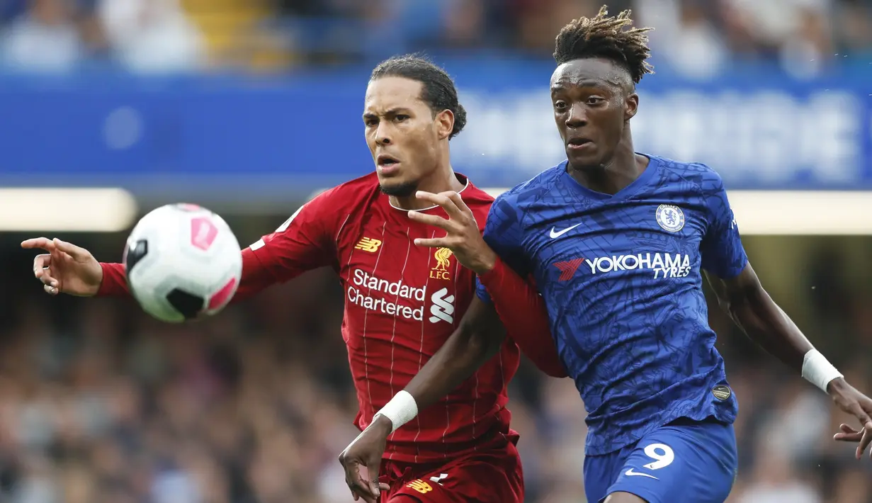 Bek Liverpool, Virgil van Dijk (kiri) berebut bola dengan penyerang Chelsea, Tammy Abraham selama pertandingan lanjutan Liga Inggris di Stadion Stamford Bridge, London (22/9/2019). Liverpool menang tipis atas Chelsea 2-1. (AP Photo/Frank Augstein)