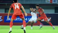 Pemain Ratchaburi FC, Faiq Jefri Bolkiah (tengah), memberikan umpan dibayangi pemain Persija Jakarta, Muhammad Ferarri (kanan), dalam pertandingan uji coba yang berlangsung di stadion Patriot Candrabhaga, Bekasi, Minggu (25/6/2023). (Bola.com/M Iqbal Ichsan)