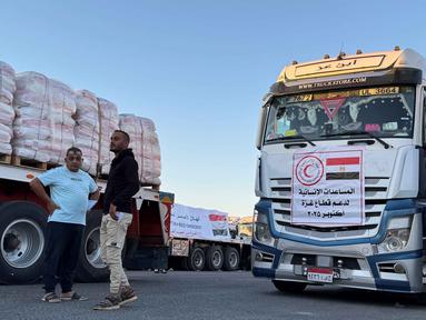 Truk-truk yang memuat bantuan kemanusiaan di sisi Mesir dari perlintasan Rafah menunggu untuk menyeberang ke Jalur Gaza pada 15 Oktober 2025. (Foto oleh AFP)
