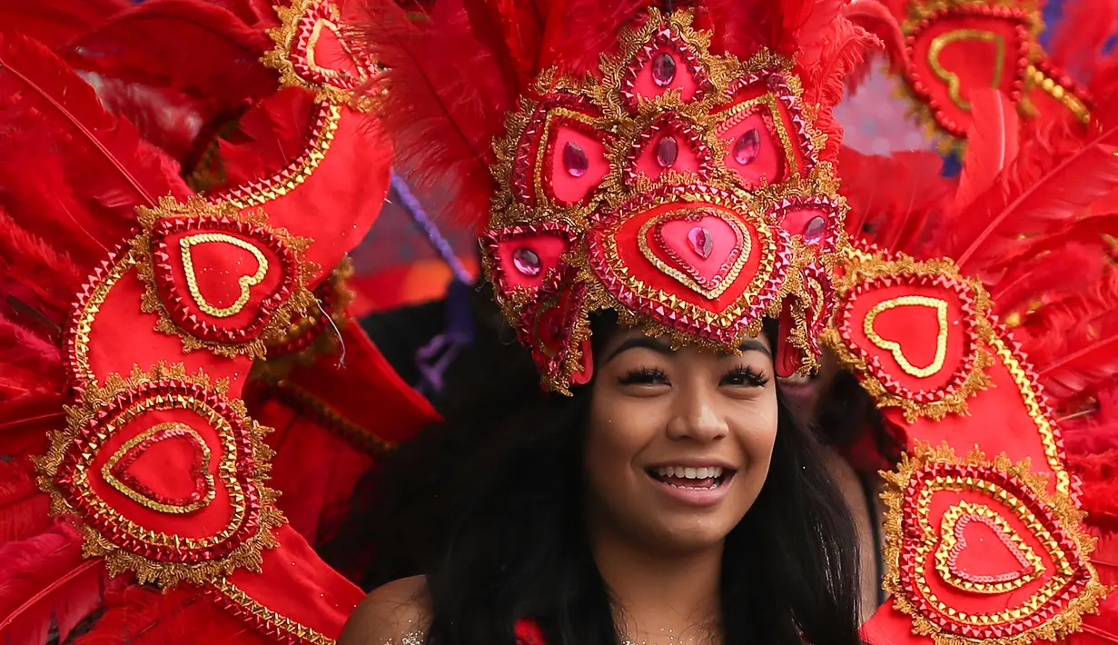 Seorang penari ambil bagian pada parade hari pertama Karnaval Notting Hill di London barat, Minggu (26/8). Ajang ini sebagai bentuk penghormatan setelah ribuan imigran dari Karabia meminta suaka ke Inggris pada tahun 1950-an. (AFP/Daniel LEAL-OLIVAS)
