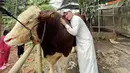 Anwar yang mengenakan gamis putih pun nampak memeluk sapi hewan kurbannya tersebut. @anwar_bab