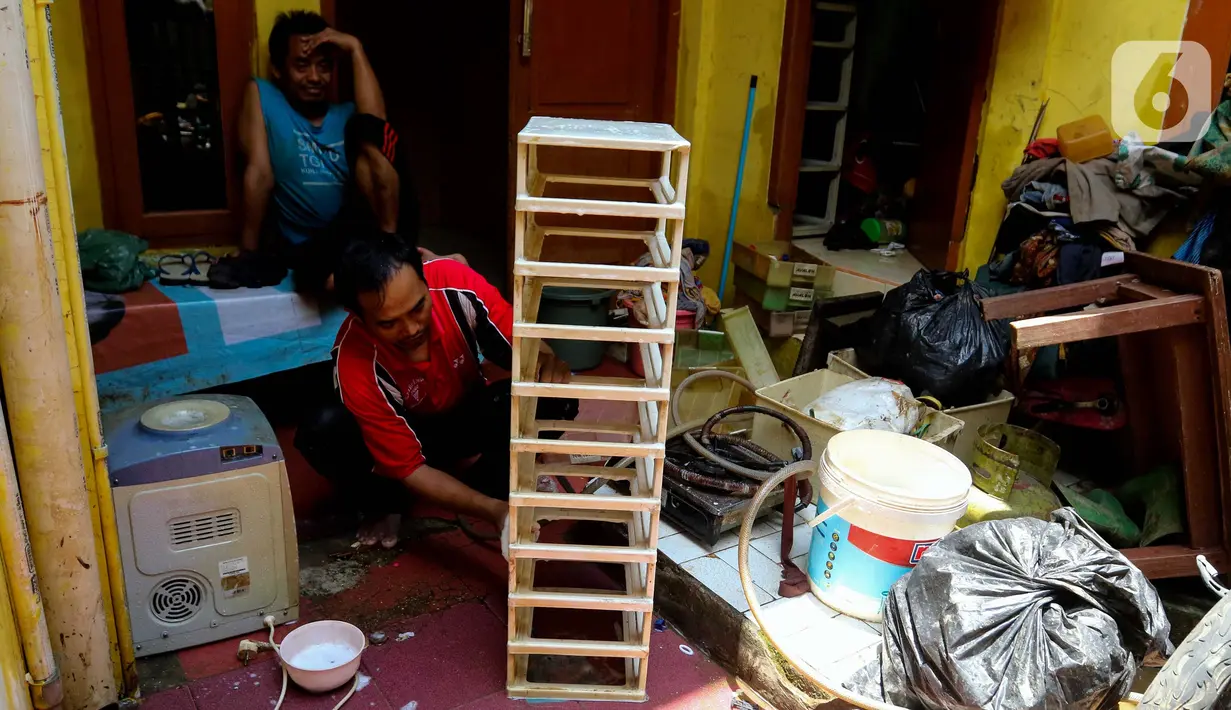 Warga membersihkan perabot rumah tangga dari sisa endapan lumpur di depan rumahnya pasca-banjir di Kawasan Jatinegara Barat, Jakarta Timur, Rabu (5/3/2025). (Liputan6.com/Herman Zakharia)
