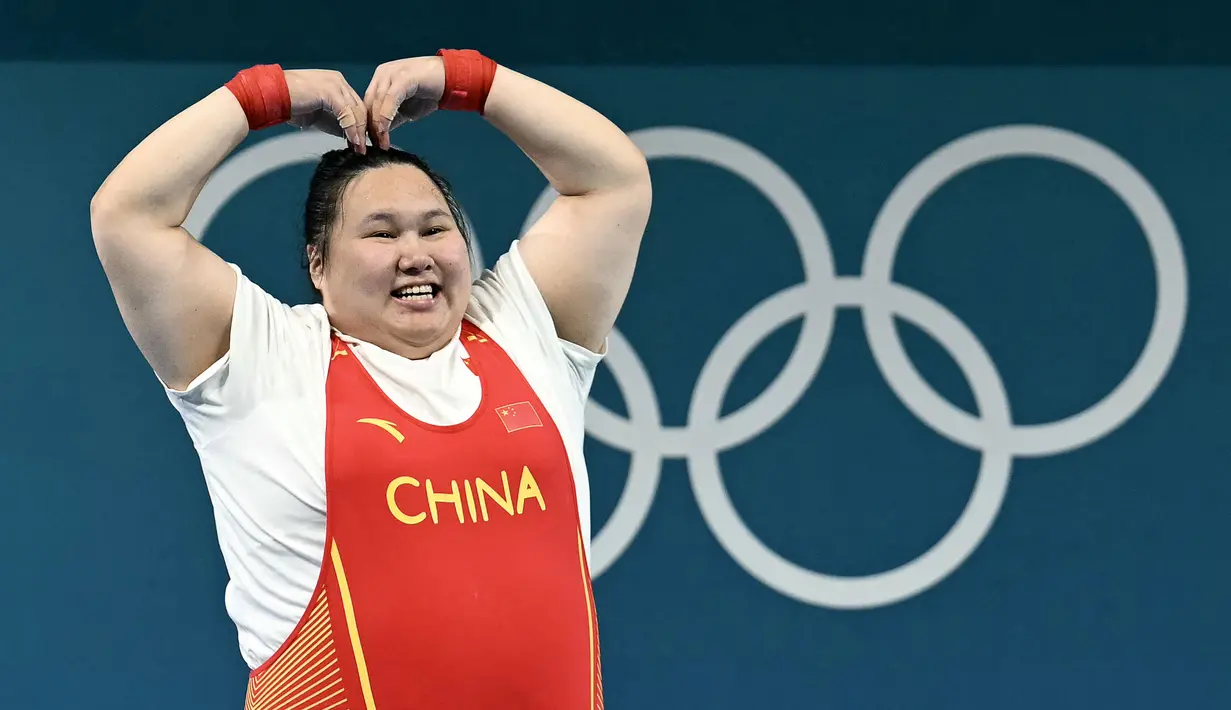 Lifter China, Li Wenwen melakukan selebrasi dengan membuat gestur hati setelah memastikan dirinya meraih medali emas cabang olahraga angkat besi +81kg putri Olimpiade Paris 2024 di South Paris Arena, Paris, Prancis, Sabtu (11/08/2024). Li Wenwen berhasil mempertahankan gelarnya di Olimpiade Paris 2024 setelah melakukan angkatan 309kg, dengan rincian 136kg snatch dan 173kg clean and jerk. (AFP/Arun Sankar)