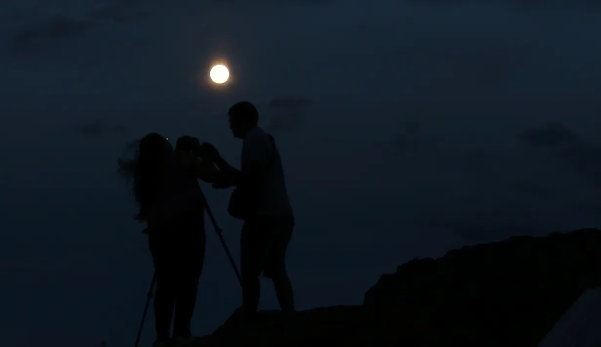 Pasangan mengambil gambar supermoon di Ischigualasto Provincial Park, San Juan, Argentina(13/11). Supermoon kali ini menjadi bulan purnama paling dekat ke bumi sejak 26 Januari 1948. (REUTERS/Enrique Marcarian)