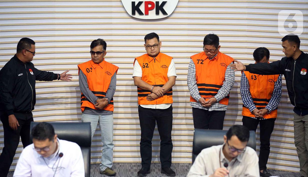 Sementara, Ahmad Thoha alias Anang dan Mendra S.B yang merupakan pihak swasta dijerat dengan pasal 5 ayat 1 huruf a atau pasal 5 ayat 1 huruf b atau pasal 13 UU nomor 31 Tahun 1999 Tipikor juncto pasal 55 ayat 1 ke-1 KUHP. Tampak dalam foto, Mendra SB; Anggota Dewan Perwakilan Rakyat Daerah (DPRD) Kabupaten Ogan Komering Ulu periode 2024-2029, Robi Vertigo; Wakil Ketua Dewan Perwakilan Rakyat Daerah (DPRD) Kabupaten Ogan Komering Ulu periode 2024-2029, Parwanto; dan Ahmat Thoha (memakai rompi tahanan dari kiri ke kanan) saat mengikuti rilis penetapan penahanan di Gedung Merah Putih Komisi Pemberantasan Korupsi (KPK), Jakarta, Kamis 20 November 2025. (Liputan6.com/Helmi Fithriansyah)