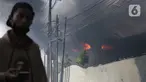 Asap hitam membumbung dari atas Gudang JNE Express yang terbakar di Jalan Pekapuran Raya, Depok, pada Senin (12/9/2022). JNE menjamin barang milik konsumen yang rusak  dalam peristiwa kebakaran gudang di Depok akan diganti. (Liputan6.com/Herman Zakharia)