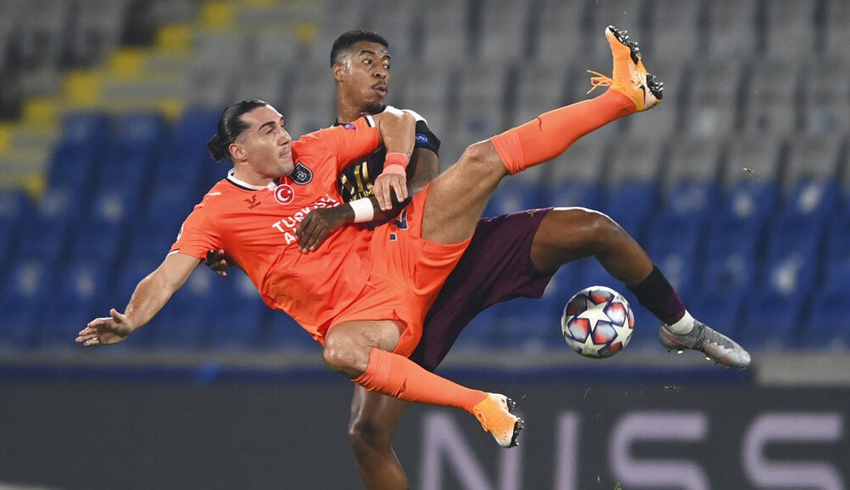 Pemain Paris Saint Germain (PSG), Presnel Kimpembe, berebut bola dengan pemain Istanbul Basaksehir, Enzo Crivelli, pada laga Liga Champions di Stadion Basaksehir Fatih Terim, Kamis (29/10/2020). PSG menang dengan skor 2-0. (Tolga Bozoglu/Pool via AP)