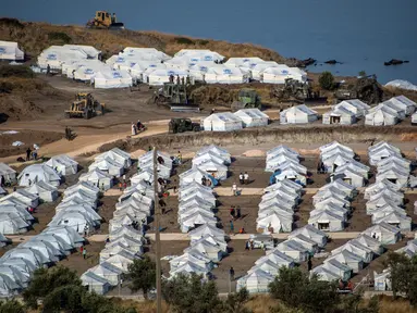 Alat berat beroperasi saat para migran berkumpul di kamp tenda sementara di Kara Tepe, Lesbos, Yunani, Kamis (17/9/2020). Lebih dari 5.000 pencari suaka kehilangan tempat tinggal sepekan setelah kebakaran menghanguskan kamp migran terbesar di Yunani, Kamp Moria. (AP Photo/Panagiotis Balaskas)