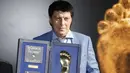 Kiper Rusia Rinat Dasaev berpose dengan trofi Golden Foot miliknya, Monaco, Senin (21/9/2015). Golden Foot 2015 diraih lima orang yaitu Rinat Dasaev, Daniel Passarella, Gheorghe Hagi,  Trezeguet dan Eto'o. (AFP Photo/Valery Hache)