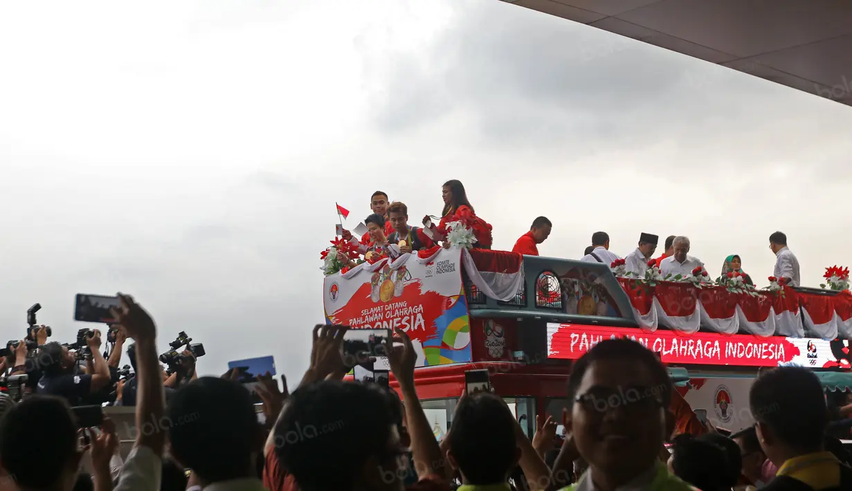 Tontowi Ahmad, Liliyana Natsir, Eko Yuli dan Sri Wahyuni menaiki bus Bandros di Terminal 3, Bandara Soekarno-Hatta, Banten, Selasa (23/8/2016). (Bola.com/Nicklas Hanoatubun)