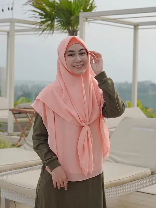 Kacamata dengan frame tipis serta hijab berwarna pink dan baju hijau tua melengkapi senyuman wanita kelahiran Bandung ini. (Liputan6.com/IG/@anisarahma_12)