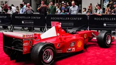 Pengunjung melihat mobil mantan pembalap Ferrari F1 dari Jerman, Michael Schumacher saat dipamerkan di perayaan ulang tahun Ferrari ke-70 di Rockefeller Plaza, New York, AS (8/10). (AFP Photo/Jewel Samad)