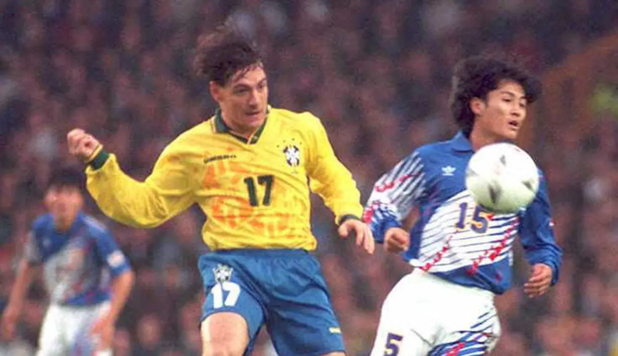 <p>Pemain Jepang Kazuyoshi Miura berebut bola dengan pemain Brasil, Doriva selama pertandingan Piala Umbro di Liverpool pada 6 Juni 1995. Sejauh ini, Kazuyoshi Miura telah mencetak 55 gol dalam 89 pertandingan untuk Jepang. (AFP/Str/Ian McCARNEY / AFP)</p>