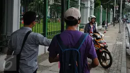 Perwakilan komunitas peduli pejalan kaki menegur pengguna motor yang parkir di trotoar Jalan Medan Merdeka Timur, Jakarta, Jumat (17/3). Mereka menghimbau pengguna motor untuk tidak melewati dan parkir di trotoar jalan. (Liputan6.com/Helmi Fithriansyah)