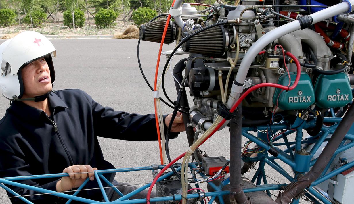 Pria 60 tahun bernama Guo Leiting saat mengecek sebuah helikopter buatannya sendiri di Yuncheng , provinsi Shanxi , Cina, 21 April 2016. Pria yang tinggal di desa ini melakukan uji coba terbang terhadap helikopter miliknya tersebut. (REUTERS / Stringer)