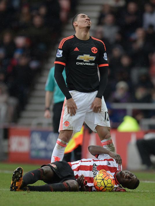 Ekspresi pemain MU, Chris Smalling, setelah melanggar pemain Sunderland, Dame N'Doye, dalam laga Liga Inggris di Stadium of Lights, Sunderland, Sabtu (13/2/2016) malam WIB. (AFP/Oli Scarff)