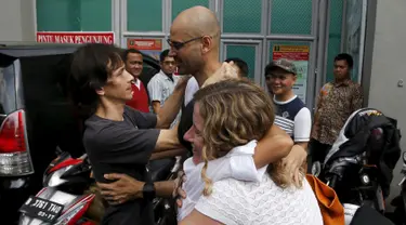 Ferdinant Tjiong (kiri) dan Neil Bantleman ditemani para istri berpelukan di depan penjara Cipinang, Jakarta (14/8/2015). Dua guru Jakarta International School (JIS) Ferdinant dan Neil diputus bebas oleh Pengadilan Tinggi Jakarta. (REUTERS/Beawiharta)