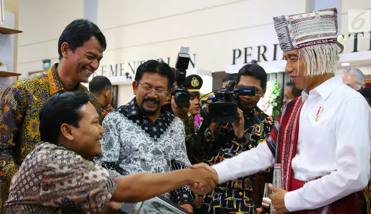 Presiden RI Jokowi bersalaman dengan Priyo Siswoyo (kiri) salah satu binaan Astra Disability Connection Program (ADCP) pada Pameran Kriyanusa Dewan Kerajinan Nasional 2017 di JCC, Rabu (27/9). (Liputan6.com/Angga Yuniar)
