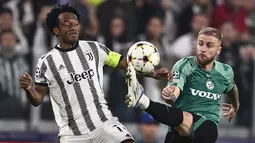 Gelandang Juventus Juan Cuadrado berebut bola dengan bek Maccabi Haifa Pierre Cornud pada matchday ketiga Grup H Liga Champions di Allianz Stadium, Kamis (6/10/2022) dini hari WIB.  Juventus berhasil menuntaskan laga dengan kemenangan 3-1. (Fabio Ferrari/LaPresse via AP)