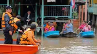 Perdana Menteri Thailand Prayuth Chan-ocha bersama tim SAR saat meninjau warga yang terjebak banjir di Distrik Sena, Ayutthaya, Thailand (5/10). Thailand mengatakan sekitar 96.000 hektare terendam dan banyak akses terputus.( Reuters/Chaiwat Subprasom)