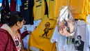 Seorang wanita melihat kaus bergambar Capres Brasil, Jair Bolsonaro dari sayap kanan di sebuah toko pinggir jalan yang populer di Sao Paulo, 8 Oktober 2018. Bolsonaro unggul dalam penghitungan suara pemilu putaran pertama. (AFP/NELSON ALMEIDA)