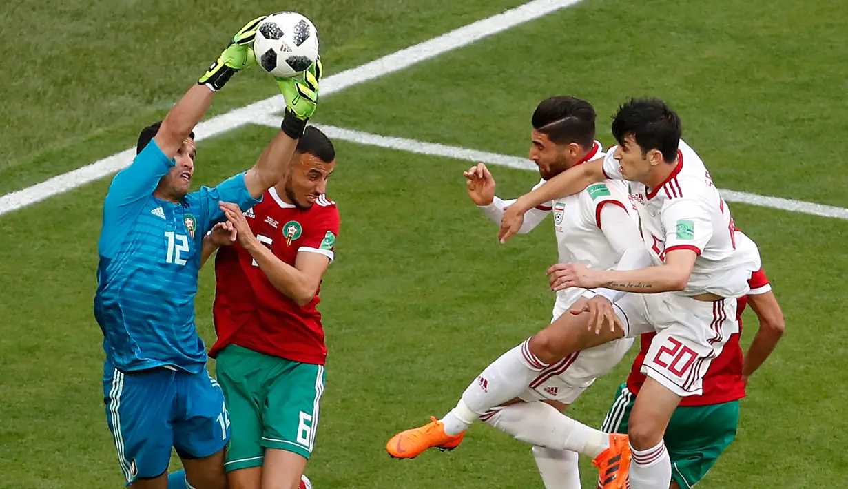 Kiper Maroko Monir El Kajoui berusaha menangkap bola saat bertanding melawan Iran pada grup B Piala Dunia 2018 di St Petersburg Stadium, Rusia, (15/6). Iran menang tipis 1-0 berkat gol bunuh diri Aziz Bouhaddouz. (AP Photo/Darko Vojinovic)