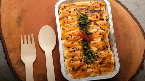 Saus mentai yang krimi dan gurih, disajikan di atas sushi roll dengan taburan nori dan wijen