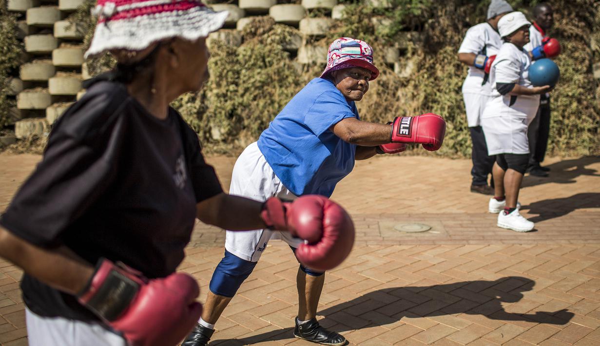 Para nenek berlatih tinju pada Boxing Gogos di Cosmo City, Johannesburg, Selasa (19/9/2017). Berkat latihan rutin yang dipimpin Claude Maphosa ini para lansia berhasil sembuh dari penyakit dan hidup lebih sehat. (AFP/Gulshan Khan) 