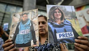 Sejumlah warga Palestina turut berduka atas kematian jurnalis tersebut. Tampak dalam foto, seorang pekerja media pemerintah memegang potret jurnalis Palestina yang telah meninggal selama demonstrasi di depan gedung PBB di Caracas pada 11 Agustus 2025. (Juan BARRETO/AFP)