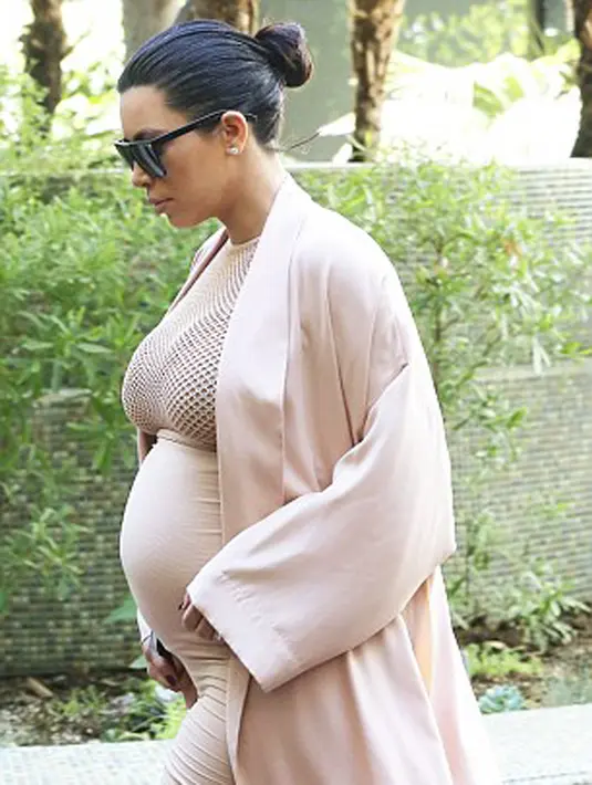 Tampilan Kim Kardashian semakin cantik dengan rambutnya yang disanggul sederhana dan seperti biasa ia memakai kacamata hitam. (via dailymail.co.uk)