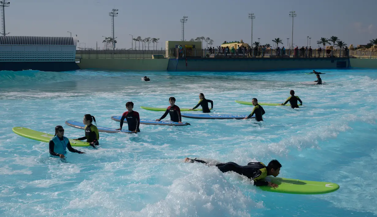 Peselancar mendapat instruksi di kolam ombak Wave Park di Siheung, Korea Selatan, 18 Oktober 2020. Korea Selatan memiliki kolam ombak terbesar di dunia dengan teknologi Wavegarden Cove yang memiliki beberapa modul produksi gelombang dan menjadi kolam gelombang dengan jumlah terbesar. (Ed JONES/AFP)