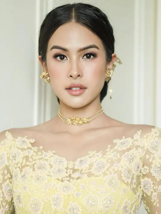 Wajahnya dirias MUA Evalovira dengan nuansa peach yang flawless.