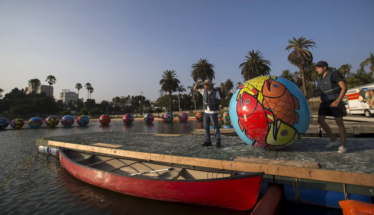 Relawan mempersiapkan bola raksasa untuk ikut dalam pameran "Spheres" di Los Angeles, California, AS (21/8/2015). Acara ini menampilkan sekitar 3.000 bola raksasa yang dihias oleh para relawan. (REUTERS/Mario Anzuoni)