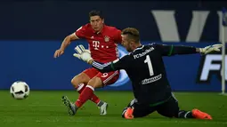 Striker Bayern Munchen, Robert Lewandowski, berusaha menaklukkan kiper Schalke 04, Ralf Faehrmann, dalam lanjutan Bundesliga di Veltins Arena, Gelsenkirchen, Sabtu (10/9/2016) dini hari WIB. (AFP/Patrik Stollarz)