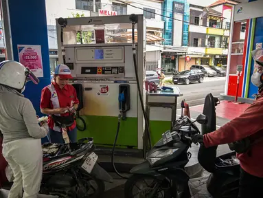 Seorang karyawan mengisi bensin motor di sebuah Stasiun Pengisian Bahan Bakar Umum (SPBU) di Surabaya, Jawa Timur, pada Senin 9 Maret 2026. Kementerian Energi dan Sumber Daya Mineral (ESDM) sedang mengkaji dampak kenaikan harga minyak mentah dunia ke harga Bahan Bakar Minyak (BBM) di Indonesia. (JUNI KRISWANTO/AFP)
